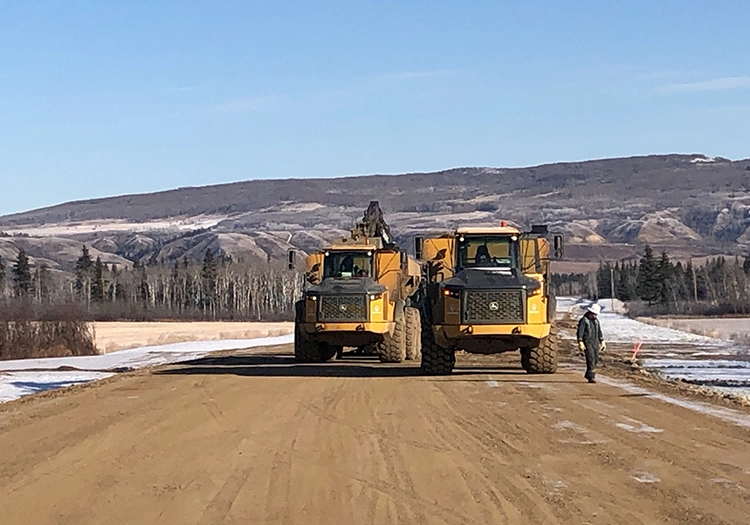 Heavy equipment driving on dirt road